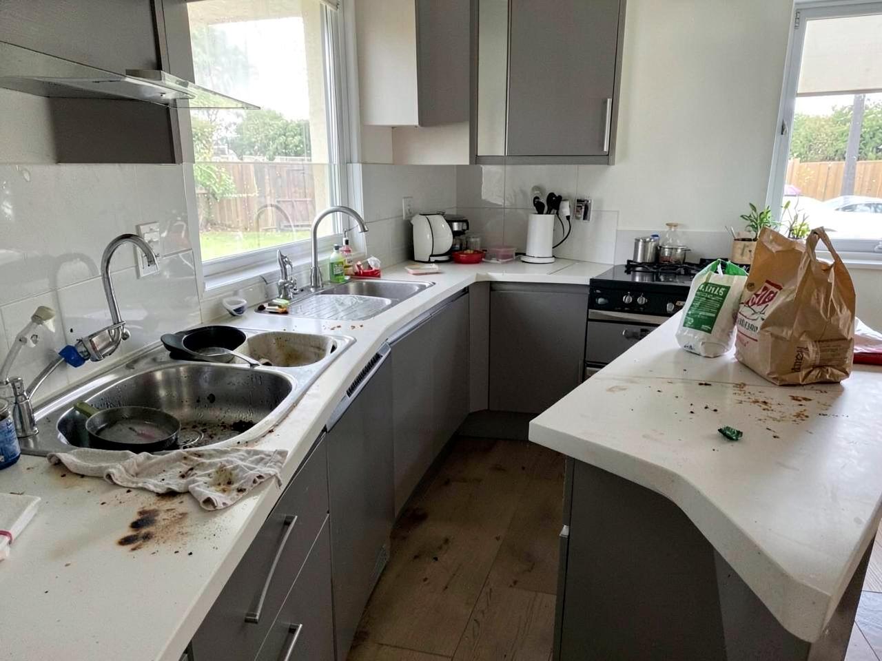 Kitchen counters with dishes and crumbs before cleaning